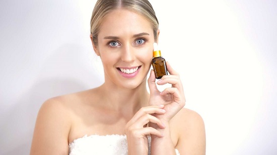 atrakcyjna kobieta używająca serum z witaminą C